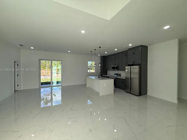 a kitchen with stainless steel appliances kitchen island granite countertop a refrigerator and a stove top oven