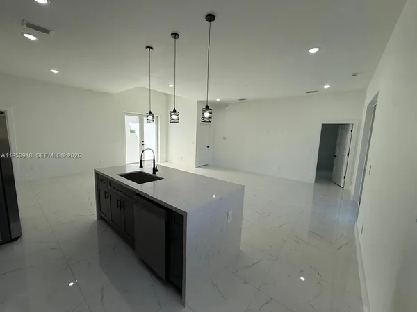 a kitchen with stainless steel appliances granite countertop a sink a refrigerator and a stove