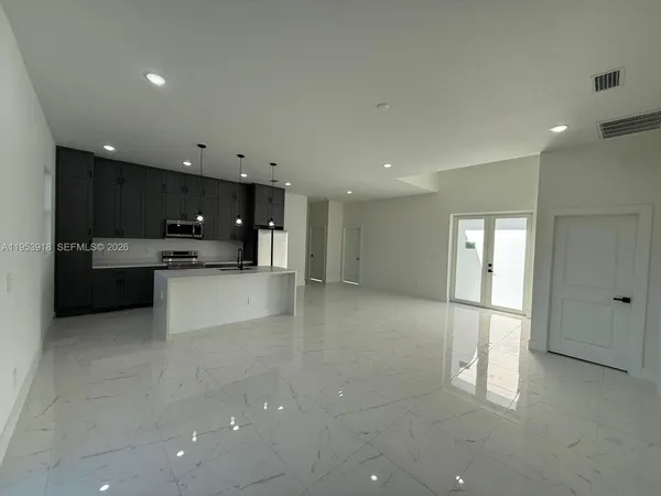 a view of a kitchen with a refrigerator and a sink