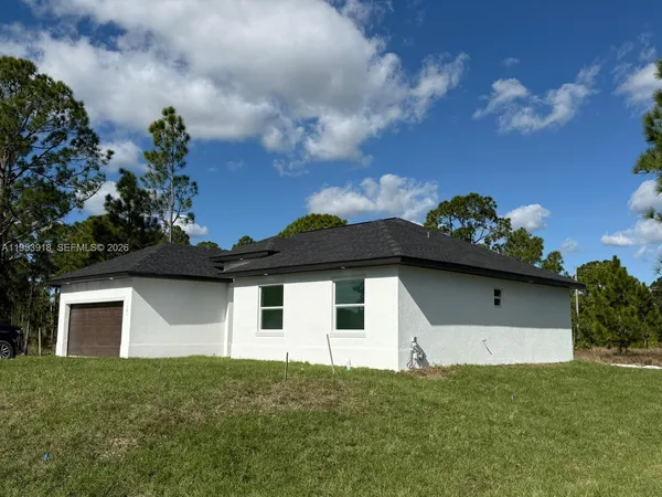 a house with green field in front of it