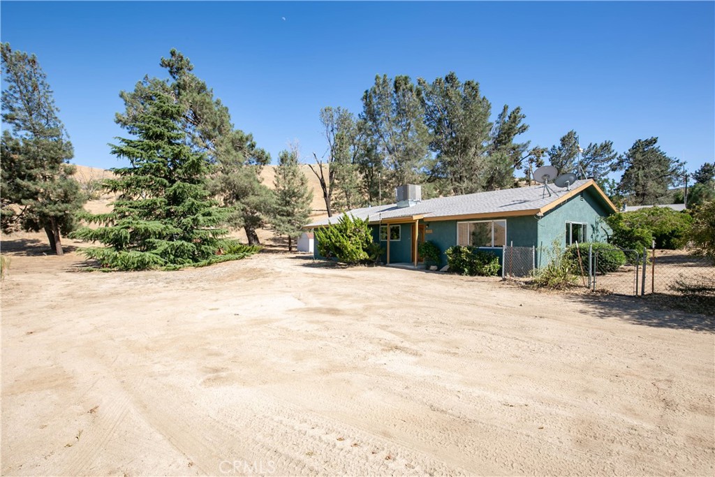 46404 Kings Canyon Road Lancaster, CA 93536 - Photo 1 of 41 a view of house with yard and trees in the background