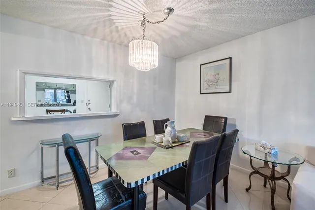 a view of a dining room with furniture a chandelier and wooden floor