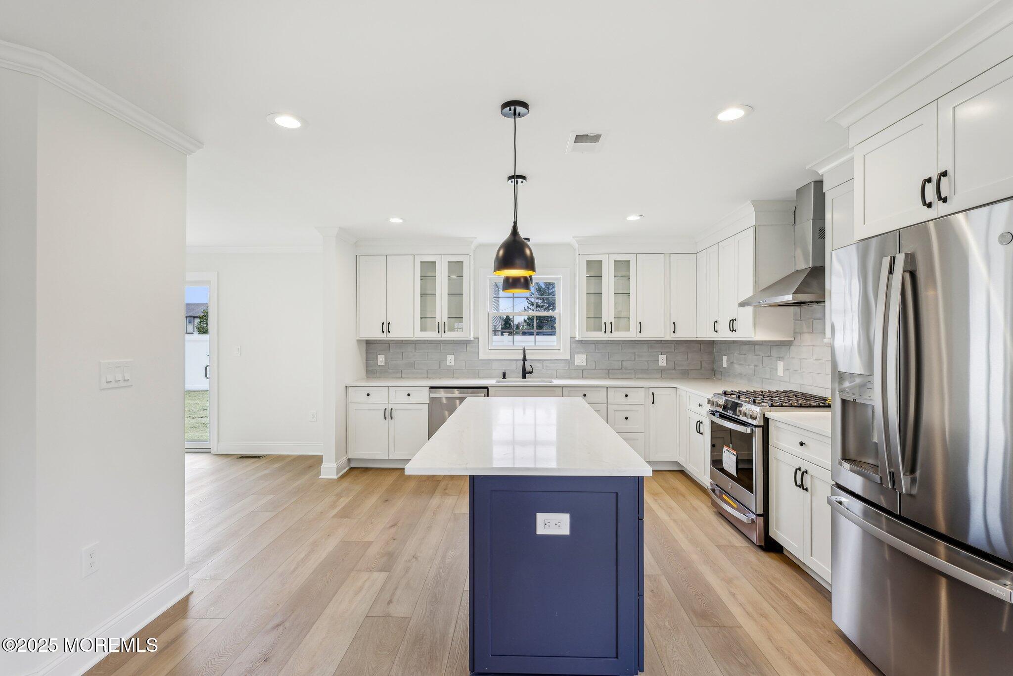 563 Holmdel Road Hazlet, NJ 07730 - Photo 13 of 50 a large kitchen with stainless steel appliances granite countertop a refrigerator a stove a sink dishwasher and white cabinets with wooden floor