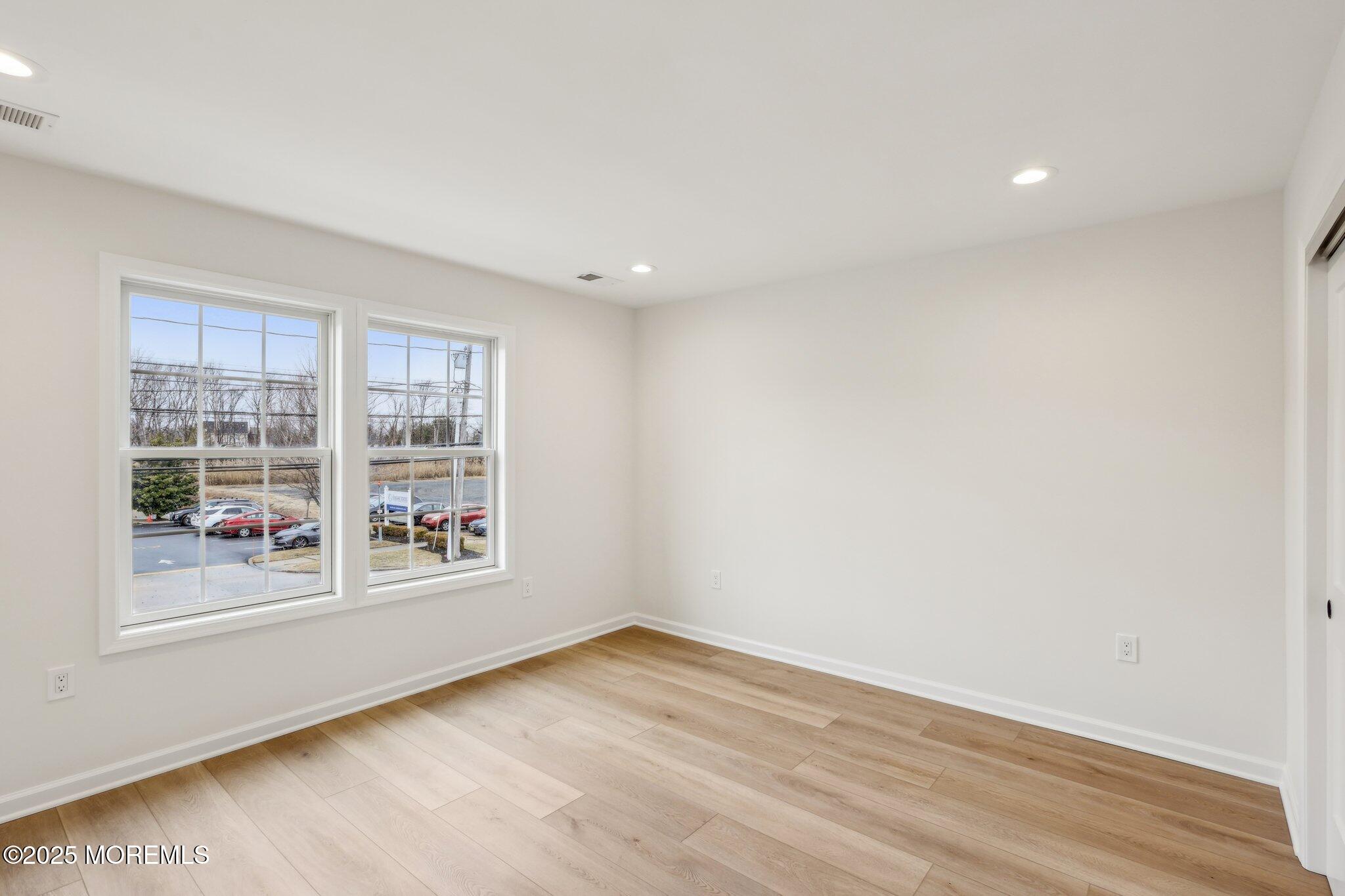 563 Holmdel Road Hazlet, NJ 07730 - Photo 27 of 50 an empty room with wooden floor and windows