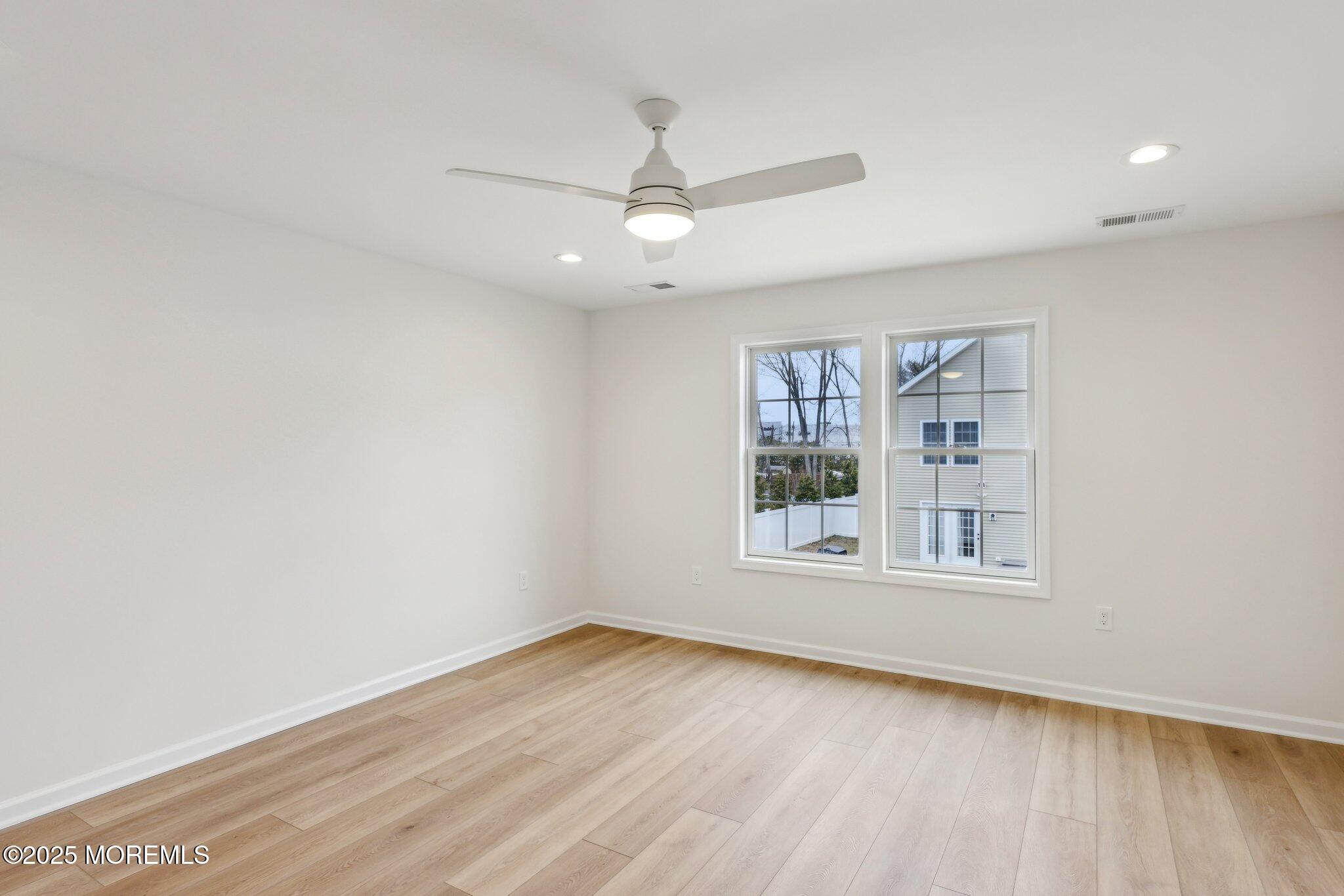 563 Holmdel Road Hazlet, NJ 07730 - Photo 28 of 50 an empty room with wooden floor and windows