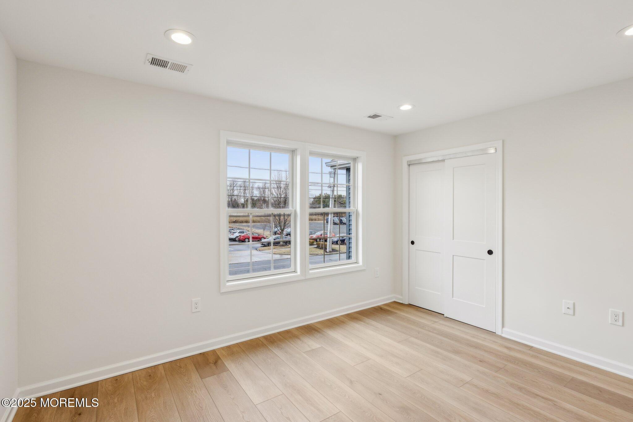 563 Holmdel Road Hazlet, NJ 07730 - Photo 36 of 50 an empty room with wooden floor and windows