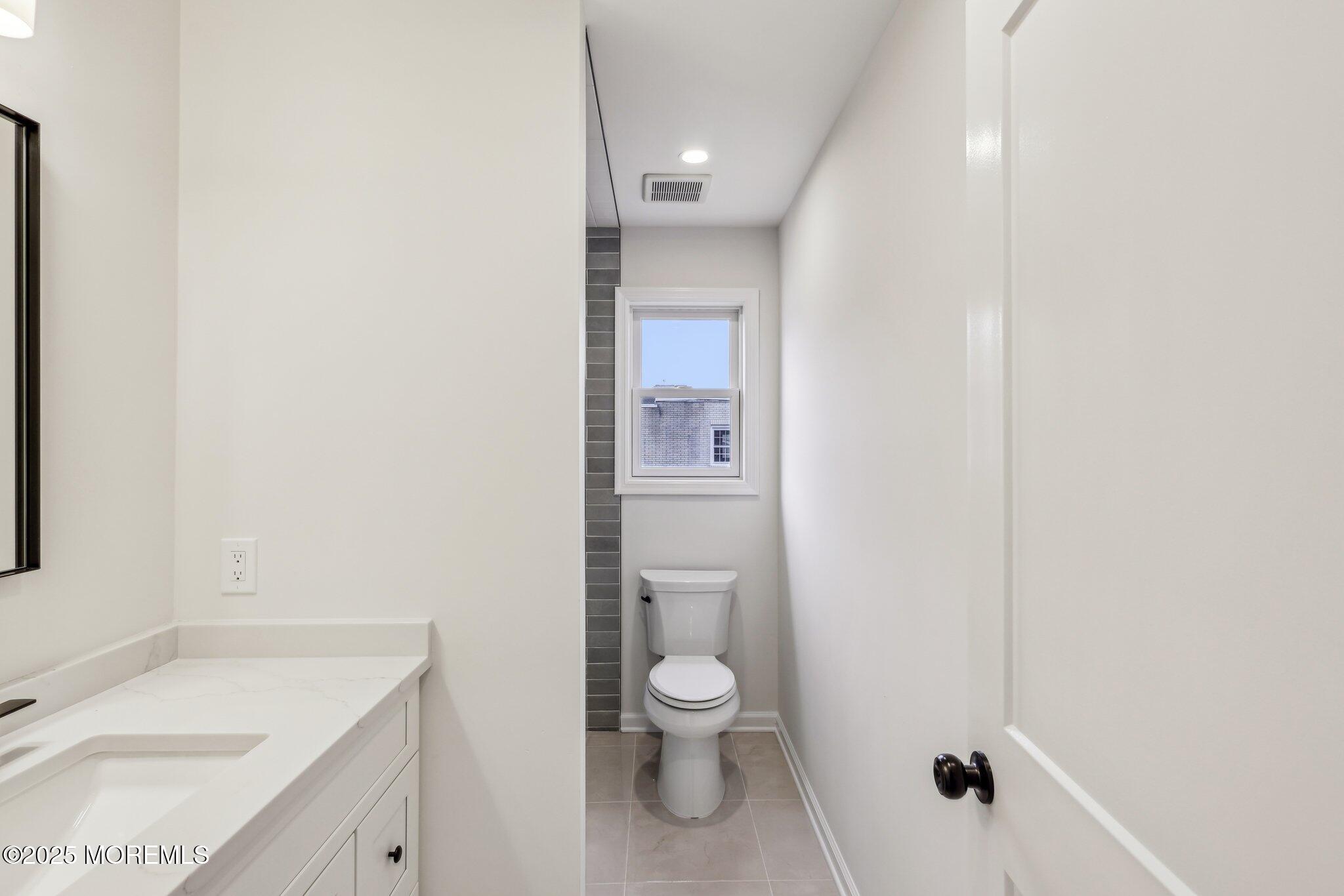 563 Holmdel Road Hazlet, NJ 07730 - Photo 42 of 50 a bathroom with a granite countertop toilet a sink and a bathtub