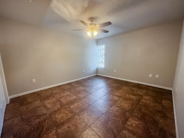 a view of an empty room with a ceiling fan