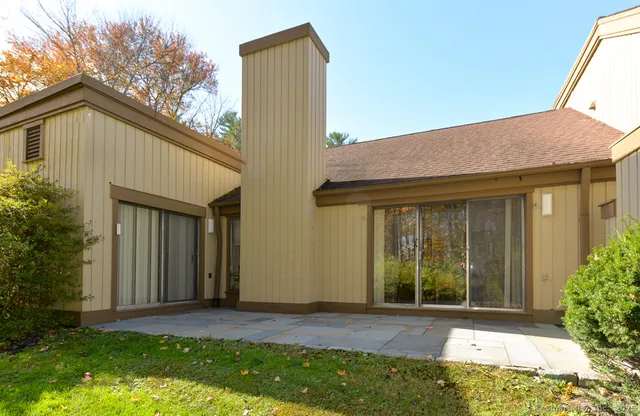 a view of house with backyard and glass windows