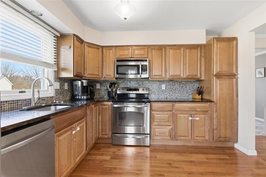 44 Rodgers Drive Coraopolis, PA 15108 - Photo 11 of 42 a kitchen with stainless steel appliances granite countertop a stove a sink and a microwave