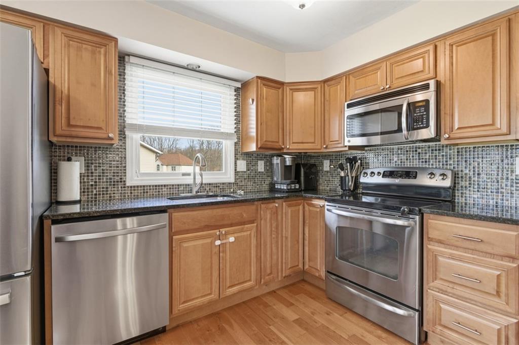 44 Rodgers Drive Coraopolis, PA 15108 - Photo 12 of 42 a kitchen with stainless steel appliances granite countertop a stove a sink and a microwave