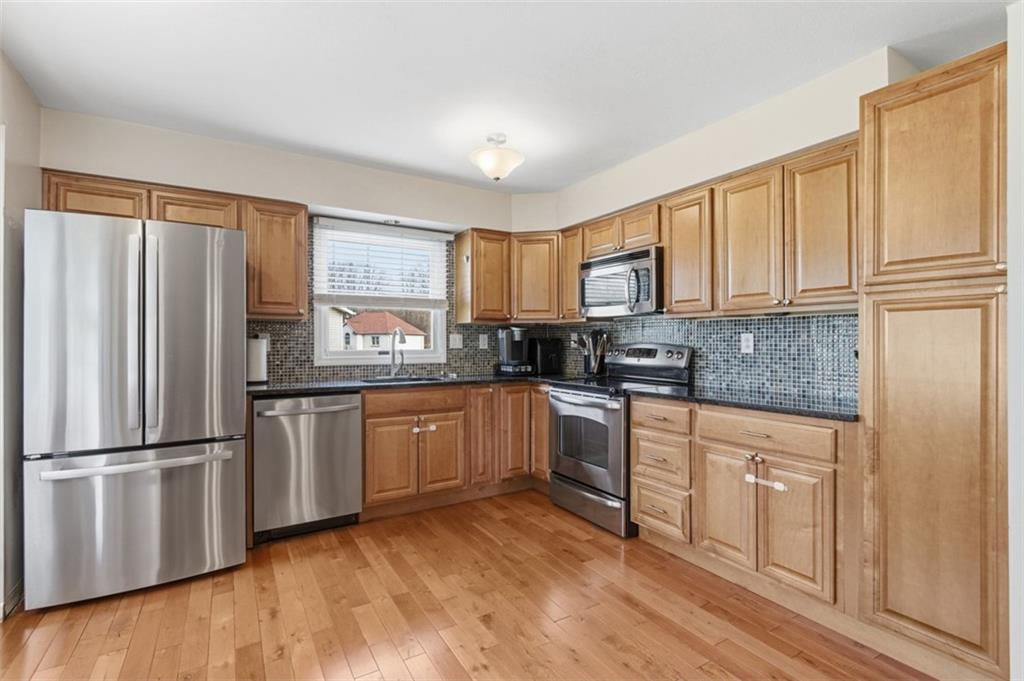 44 Rodgers Drive Coraopolis, PA 15108 - Photo 8 of 42 a kitchen with granite countertop wooden cabinets a refrigerator and a stove top oven