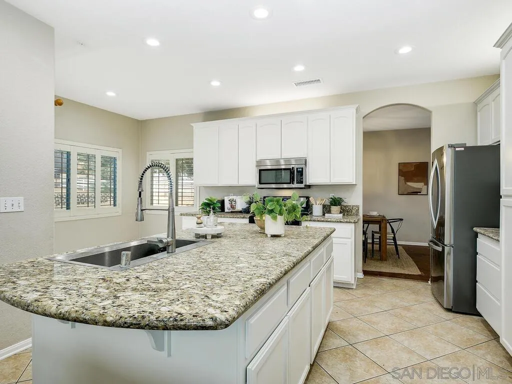 16304 Dartolo Road Ramona, CA 92065 - Photo 8 of 36 a kitchen with kitchen island granite countertop a sink stove and refrigerator