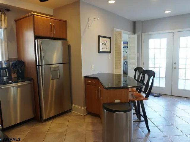 a dining room with stainless steel appliances furniture refrigerator and microwave