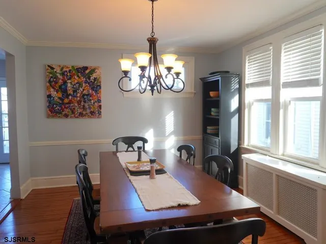 a view of a dining room with furniture a chandelier and window