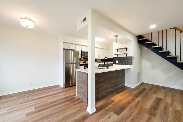a kitchen with a refrigerator and white cabinets