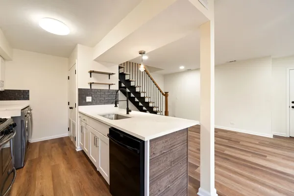 a large white kitchen with a sink a refrigerator and a stove