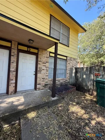 a view of a house with a small yard and wooden fence
