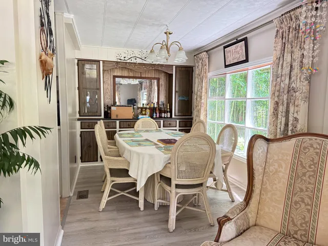 a dining room with furniture a chandelier and wooden floor
