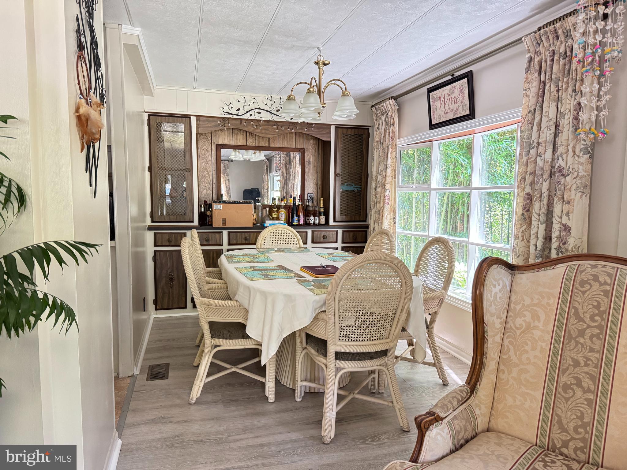 34118 Pinewood Circle, Unit 11080 Lewes, DE 19958 - Photo 12 of 22 a dining room with furniture a chandelier and wooden floor
