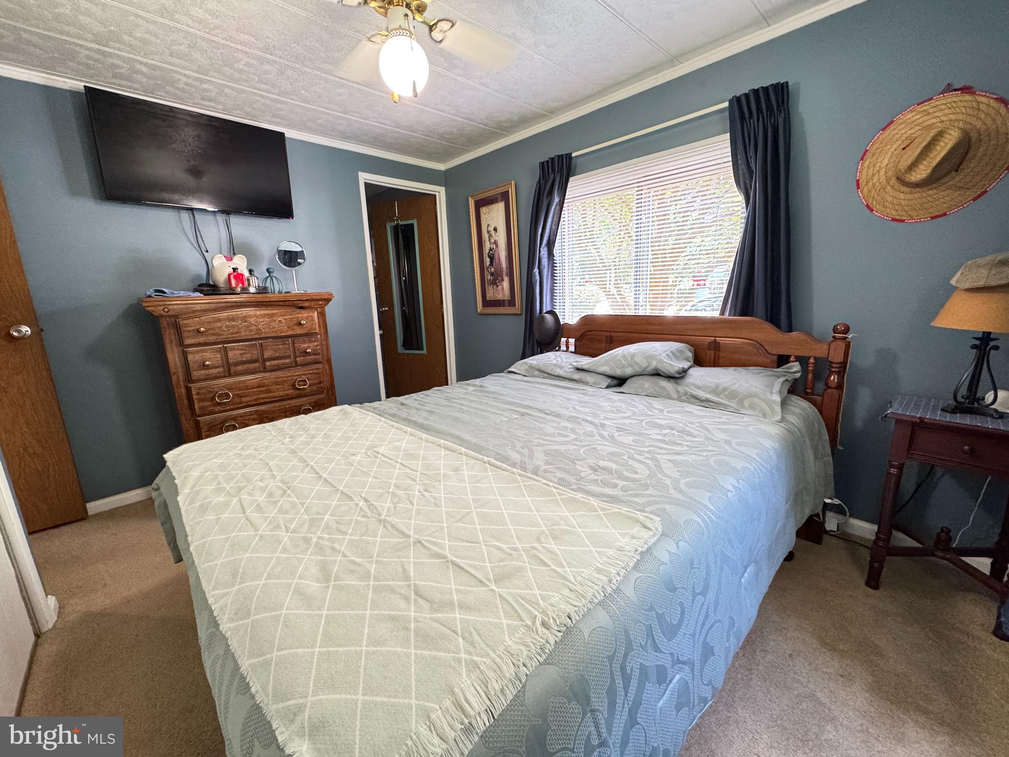 34118 Pinewood Circle, Unit 11080 Lewes, DE 19958 - Photo 13 of 22 a bedroom with a large bed and a flat tv screen on dresser