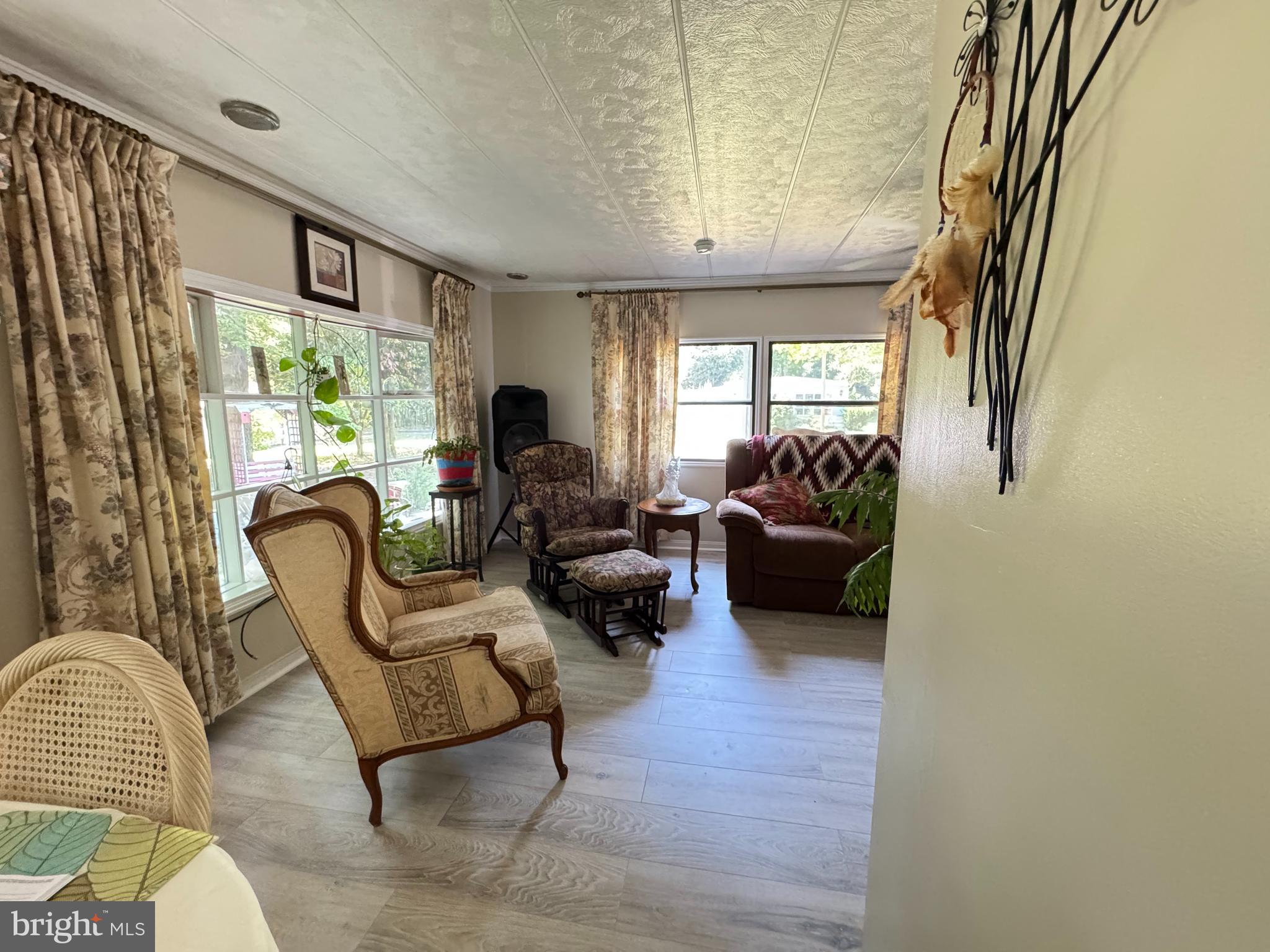 34118 Pinewood Circle, Unit 11080 Lewes, DE 19958 - Photo 8 of 22 a living room with furniture a fireplace and a large window