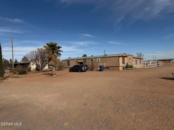a view of the house and car parked on the road