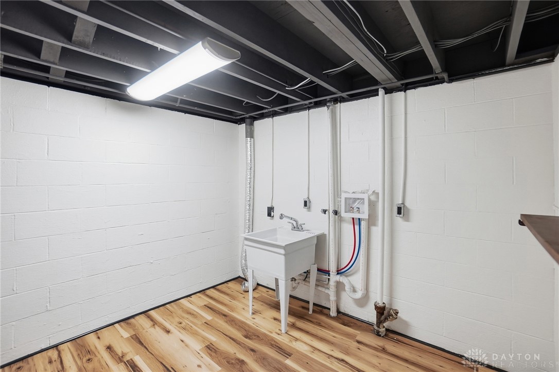 1628 Yorkshire Court Springfield, OH 45503 - Photo 35 of 47 This spacious laundry room offers practicality with a utility sink and durable wood flooring.