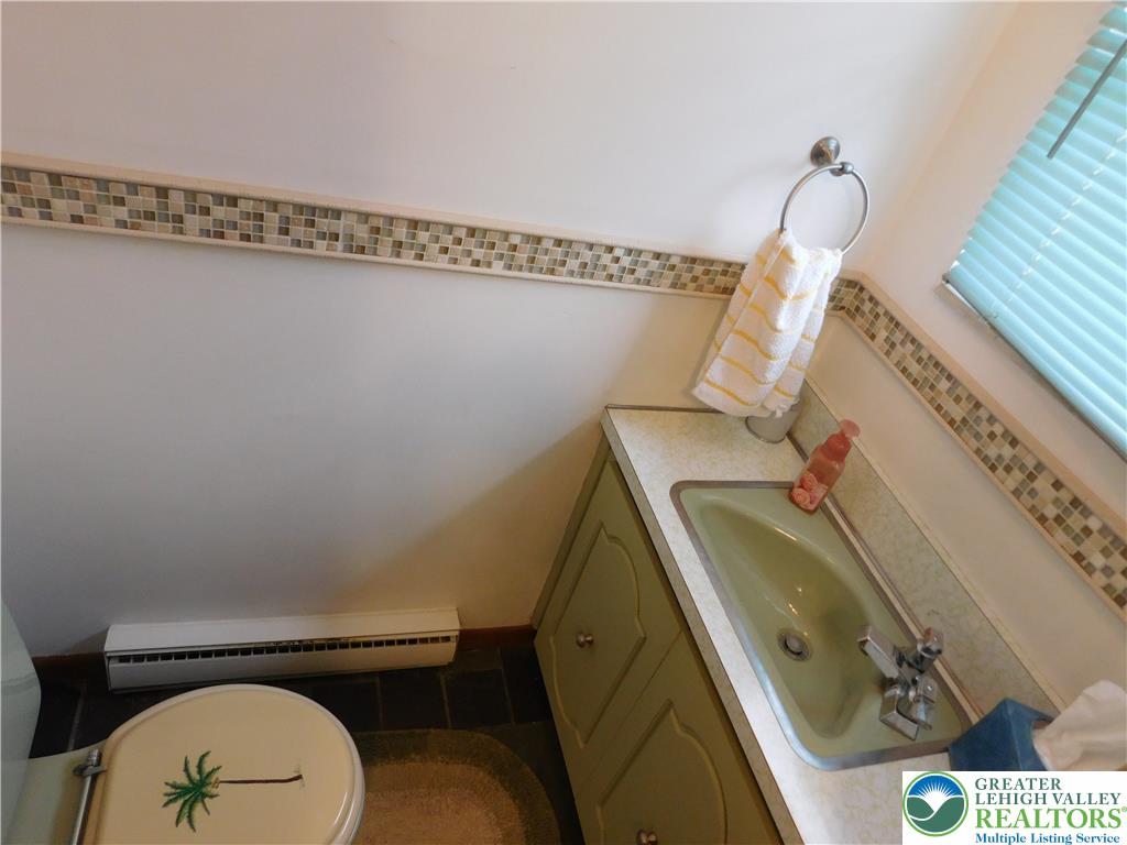 21 Will Barnesville, PA 18214 - Photo 10 of 23 A well-lit powder room featuring a patterned tiled border and practical vanity space.