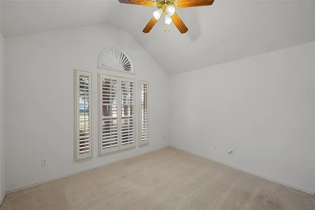 an empty room with chandelier fan