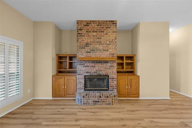 a view of an empty room with a fireplace and a window