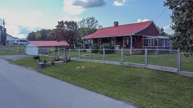 a view of a house with a yard and sitting area