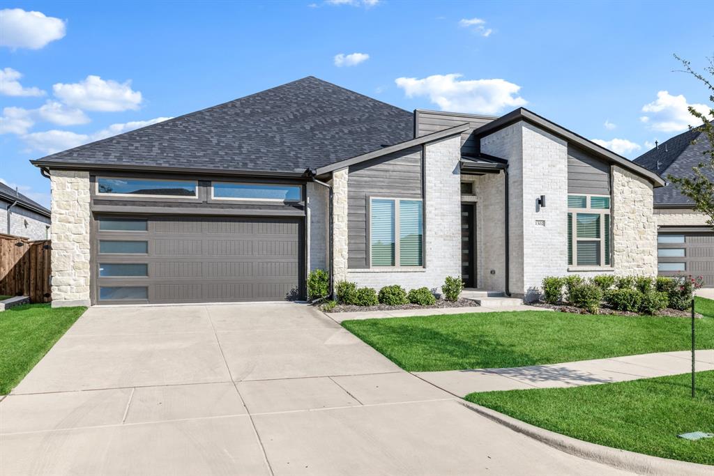 1302 Shorefront Drive Allen, TX 75013 - Photo 1 of 1 View of front of home featuring driveway, a garage, a shingled roof, brick siding, and stone siding