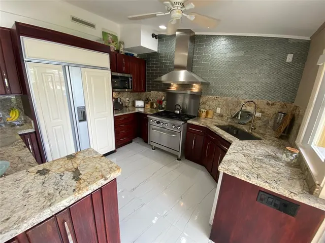 a kitchen with a stove a refrigerator and a fireplace