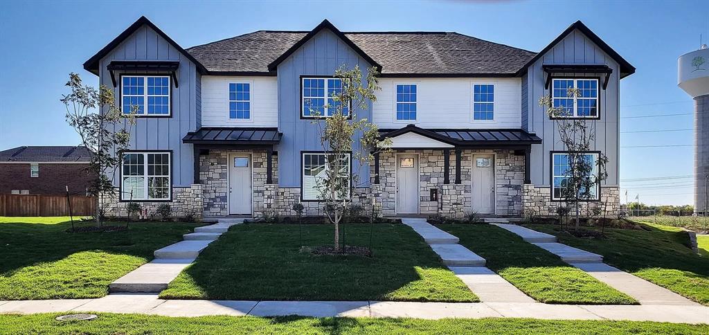 Modern duplex exterior featuring stone and vertical siding, black-framed windows, individual covered entryways, and concrete walkways