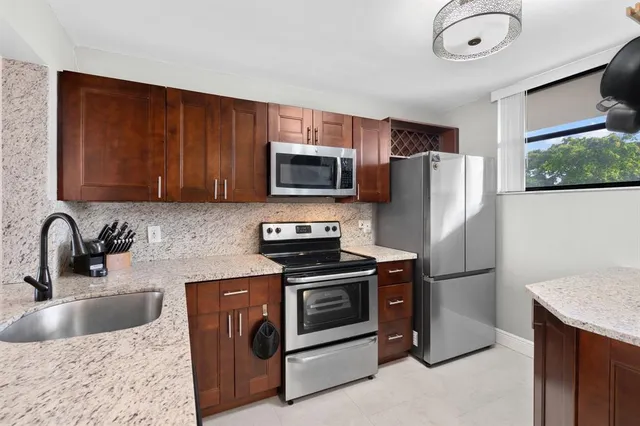 a kitchen with stainless steel appliances granite countertop a refrigerator stove and sink