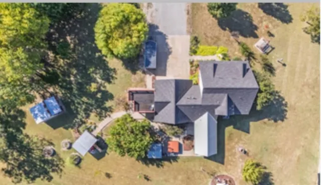 an aerial view of a house with a yard swimming pool and outdoor seating