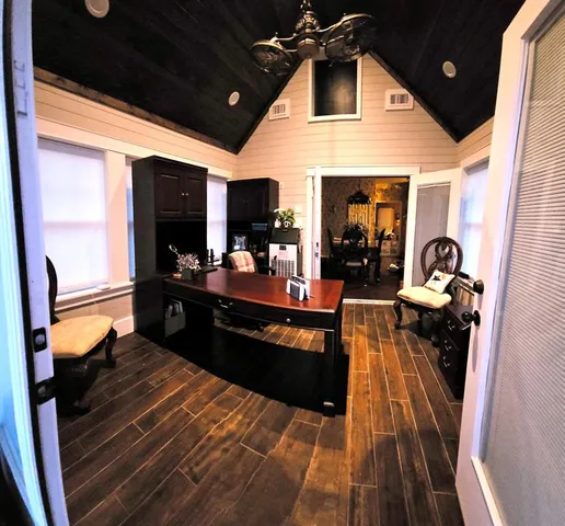 a living room with dining table and chairs with wooden floor