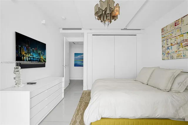 a spacious bedroom with a bed and a chandelier