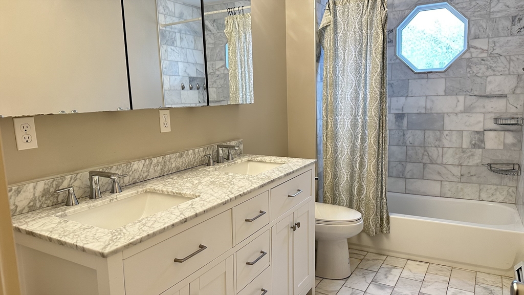 39 Snow Street, Unit SINGLE Boston, MA 02135 - Photo 13 of 28 a bathroom with a granite countertop sink a toilet and bathtub