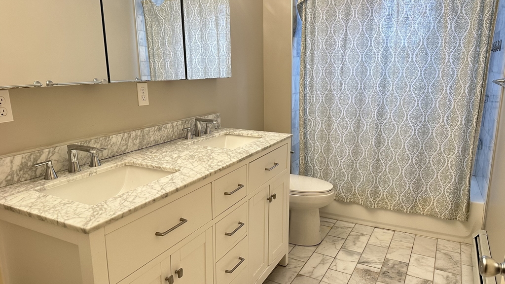 39 Snow Street, Unit SINGLE Boston, MA 02135 - Photo 14 of 28 a bathroom with a granite countertop sink toilet and a mirror