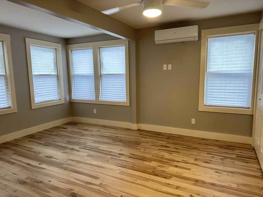 39 Snow Street, Unit SINGLE Boston, MA 02135 - Photo 17 of 28 a view of an empty room with wooden floor and a window