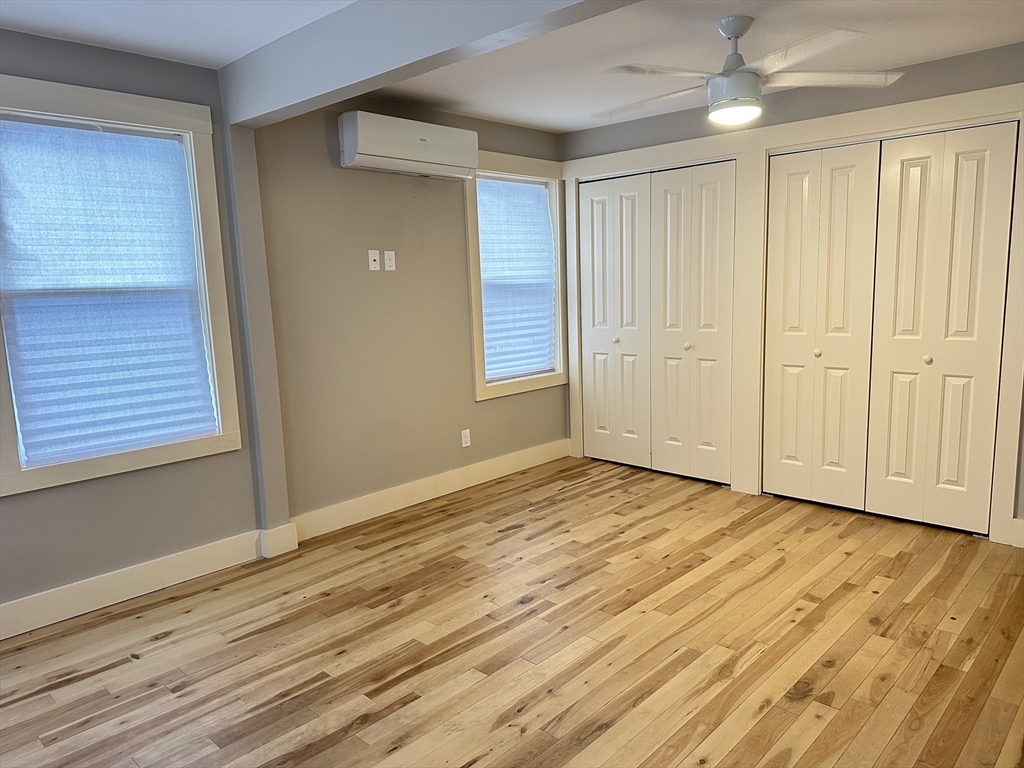 39 Snow Street, Unit SINGLE Boston, MA 02135 - Photo 19 of 28 a view of an empty room with wooden floor and a window