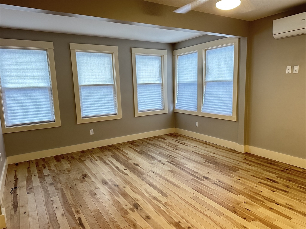 39 Snow Street, Unit SINGLE Boston, MA 02135 - Photo 22 of 28 a view of an empty room with wooden floor and a window