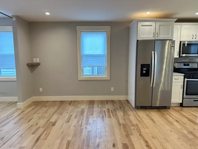 a view of a kitchen with wooden floor and a refrigerator