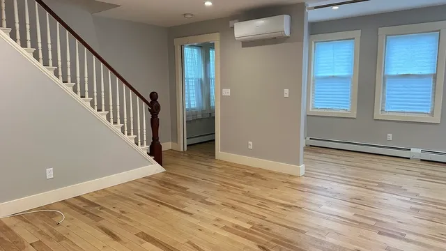 a view of a hallway with wooden floor and staircase