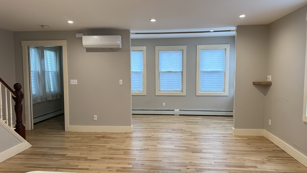 39 Snow Street, Unit SINGLE Boston, MA 02135 - Photo 10 of 28 an empty room with wooden floor and windows