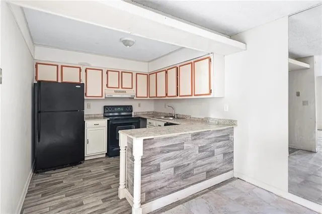 a kitchen with a refrigerator and a stove top oven