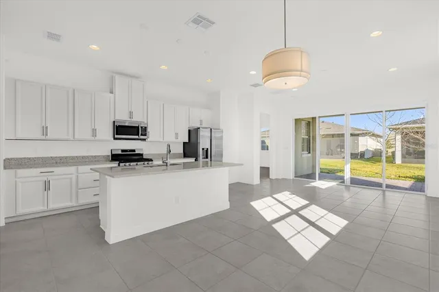 a kitchen with stainless steel appliances granite countertop a sink a stove and a refrigerator