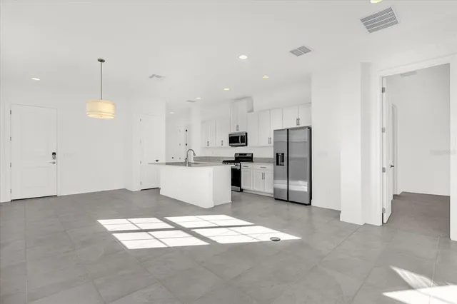 a view of kitchen with refrigerator sink and cabinets